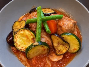 鶏肉のトマト煮込みと焼き野菜の盛り付け